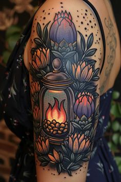 a woman's arm with an ornate lantern and flowers on the inside of it