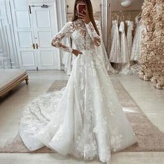 a woman taking a selfie while wearing a wedding dress in front of a mirror