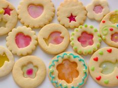 many decorated cookies are arranged on a white table top, including one cookie with hearts and stars