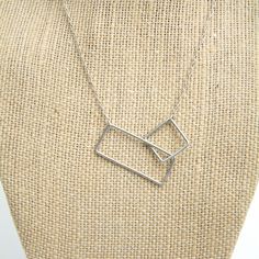 "This simple, minimalist design makes quite visual impact.  The graphic nature of the two open squares really draws your eye to this piece.  It can be worn with almost anything you choose to pair it with, making it an excellent addition to your \"jewelry wardrobe.\"  Each piece in my shop is handmade by me.  It then gets cleaned and tumbled for a minimum of 8-10 hours, adding strength and a beautiful shine to the piece. This necklace can me made in a variety of lengths, as indicated in this list Minimalist Silver Geometric Jewelry, Modern Silver Rectangular Necklaces, Adjustable Rectangular Sterling Silver Necklace, Adjustable Sterling Silver Rectangular Necklace, Modern Rectangular Necklace, Minimalist Geometric Sterling Silver Necklace, Minimalist Silver Square Jewelry, Minimalist Silver Square Necklace, Minimalist Square Silver Necklace