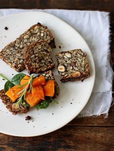 a white plate topped with slices of bread and veggies on top of it