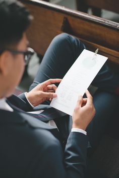 a man sitting on the ground holding a piece of paper