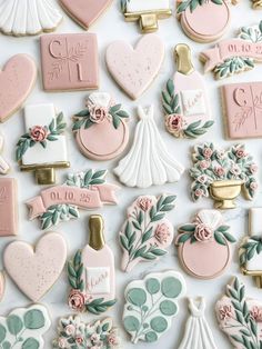 many decorated cookies are arranged on a white surface with pink and green flowers in the center