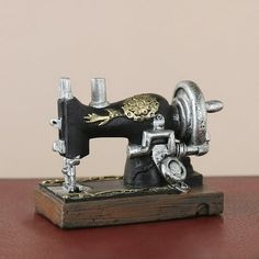 an old fashioned sewing machine sitting on top of a wooden table