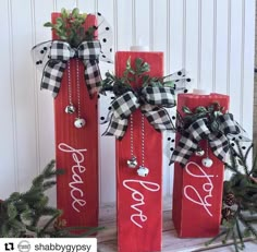 three red wine bottles decorated with black and white ribbon, one has the word love on it