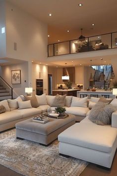 a living room filled with lots of furniture and a stair case in the back ground