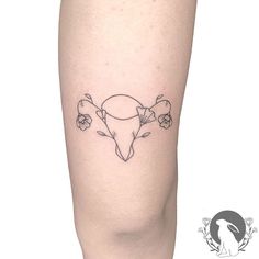 a tattoo on the leg of a woman with flowers in her hair and a cow's head