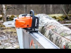 an orange and black chainsaw sitting on top of a tree