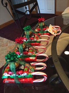 candy canes wrapped in green and red bows are sitting on a glass table top