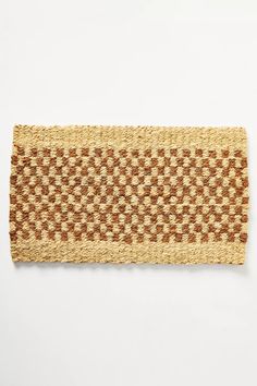 a woven piece of material on a white surface with brown and tan squares in the middle