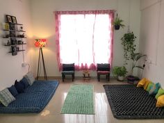 a living room with two couches and a rug on the floor in front of a window