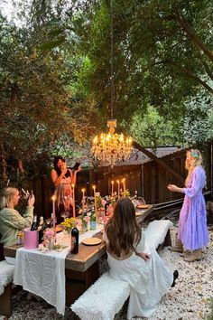 a group of women sitting around a table with candles on it