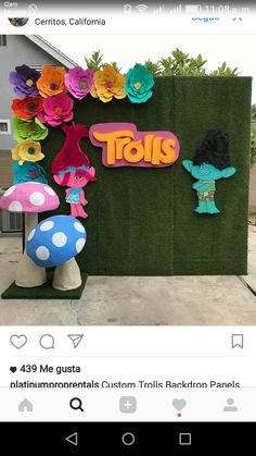 an image of a sign that says tols on the side of a wall with flowers and mushrooms