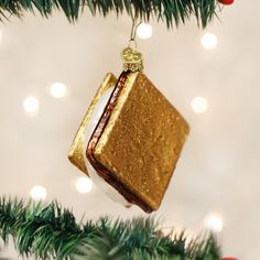 an ornament hanging from a christmas tree decorated with gold and white glitters