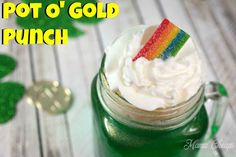 a cup with whipped cream and a rainbow flag sticking out of it's top