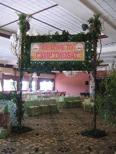 a welcome to camp lindsay sign hanging from the ceiling in a banquet hall