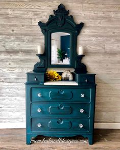 a blue dresser with a mirror and candles on top