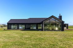 a black house sitting on top of a lush green field