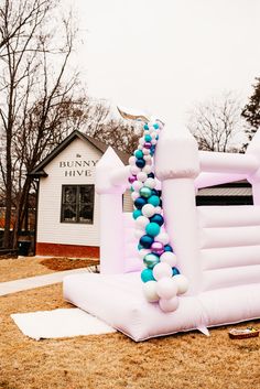 an inflatable arch with blue and white balloons attached to it on the ground