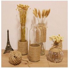 there are vases with flowers in them next to the eiffel tower and a ball of twine