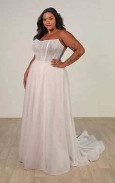 a woman in a white dress posing for the camera with her hands on her hips