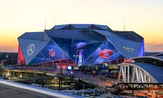 the stadium is lit up at night and it's bright blue with red accents