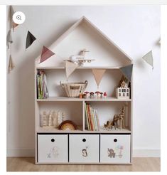 a toy house shelf with toys and books on it in front of a white wall