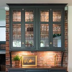 a kitchen with brick walls and green cabinets