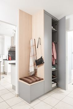 a coat rack with two coats hanging from it's sides in a white room