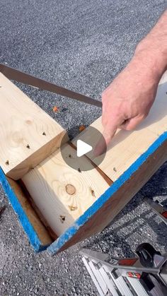 a person using a pair of scissors to cut wooden planks with a sawtooth