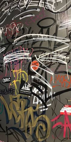 graffiti on the side of a wall with different colors and sizes, including black, white, red, blue, yellow