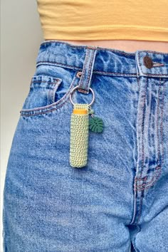 a person wearing blue jeans with a banana keychain attached to the back of their pants