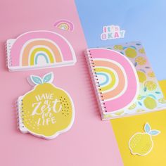 two notebooks with stickers on them next to each other