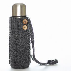 a knitted water bottle cover with buttons on the side and a chain around it