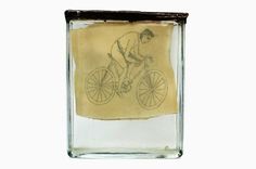 a glass block with a drawing of a man riding a bike