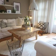 a living room filled with white furniture and lots of pillows on top of a rug