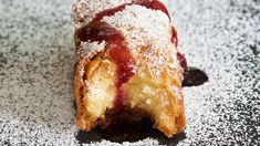 a pastry with powdered sugar and jelly on it