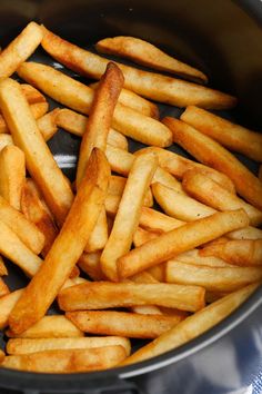 french fries are being cooked in a pot