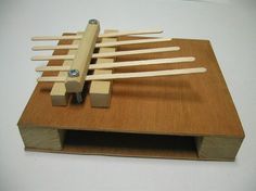 a wooden structure with several sticks sticking out of it and a screwdriver in the middle