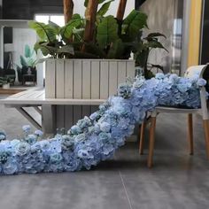 blue hydrangeas are arranged on the floor in front of a table and chairs