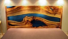 a bed with wooden headboard made out of wood and blue water painted on it