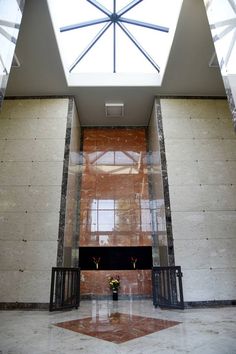 the inside of a building with a skylight above it and flowers on the ground