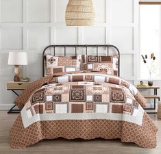 a bed with brown and white bedspread in a room next to a lamp