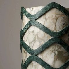 a close up of a marble vase with green ribbon around it's neck and sides