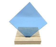 an abstract sculpture made out of blue and beige paper on top of wooden blocks with a white background