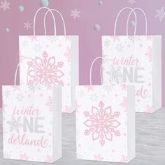 three white bags with pink snowflakes on them and the words winter one do