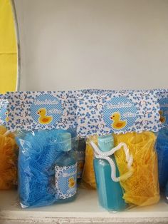 blue and yellow bags with rubber ducks on them sitting on a shelf in front of a mirror