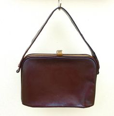 This is a stunning authentic 1930s dark brown leather handbag.  For a bag of this age it is in good condition, brass coloured metal clasp and top edging.  ( check the photos on zoom for the slight flaws)  Art Deco style clasp.  Inside lined in brown material which does have a few signs of wear on the tops of the pouch pockets.  Central zipped dividing pocket. Size  width 9.5 inches (24 cm)           depth  6.5 inches (16.5.cm)            handle 17 inches (43 cm) Antique Brown Bags For Formal Occasions, Brown Evening Shoulder Bag With Brass Hardware, Evening Brown Shoulder Bag With Brass Hardware, Vintage Brown Formal Bag, Vintage Brown Shoulder Bag For Evening, Retro Brown Satchel With Brass Hardware, Vintage Brown Antique Bag For Formal Occasions, Antique Style Vintage Brown Formal Bag, Vintage Brown Satchel With Brass Hardware