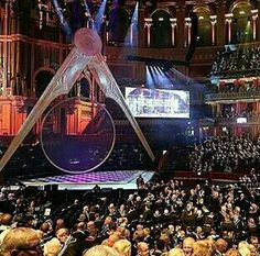 an auditorium filled with lots of people sitting down