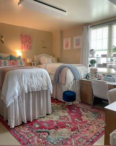 a bedroom with two beds and a rug on the floor